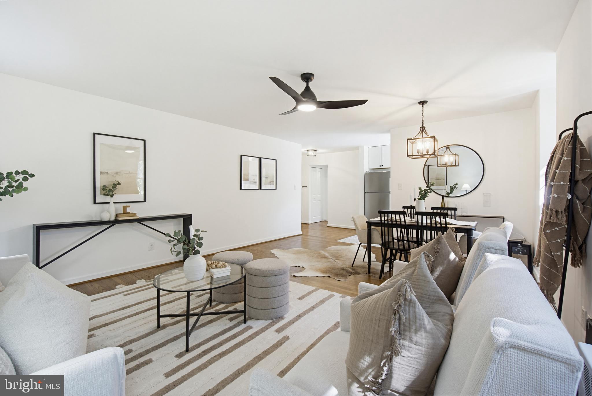 2214 Colston Drive, Unit 201 Silver Spring, MD 20910 - Photo 15 of 43 a living room with furniture a dining table and a chandelier