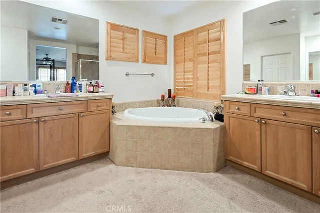 a spacious bathroom with a sink double vanity mirror and a bathtub