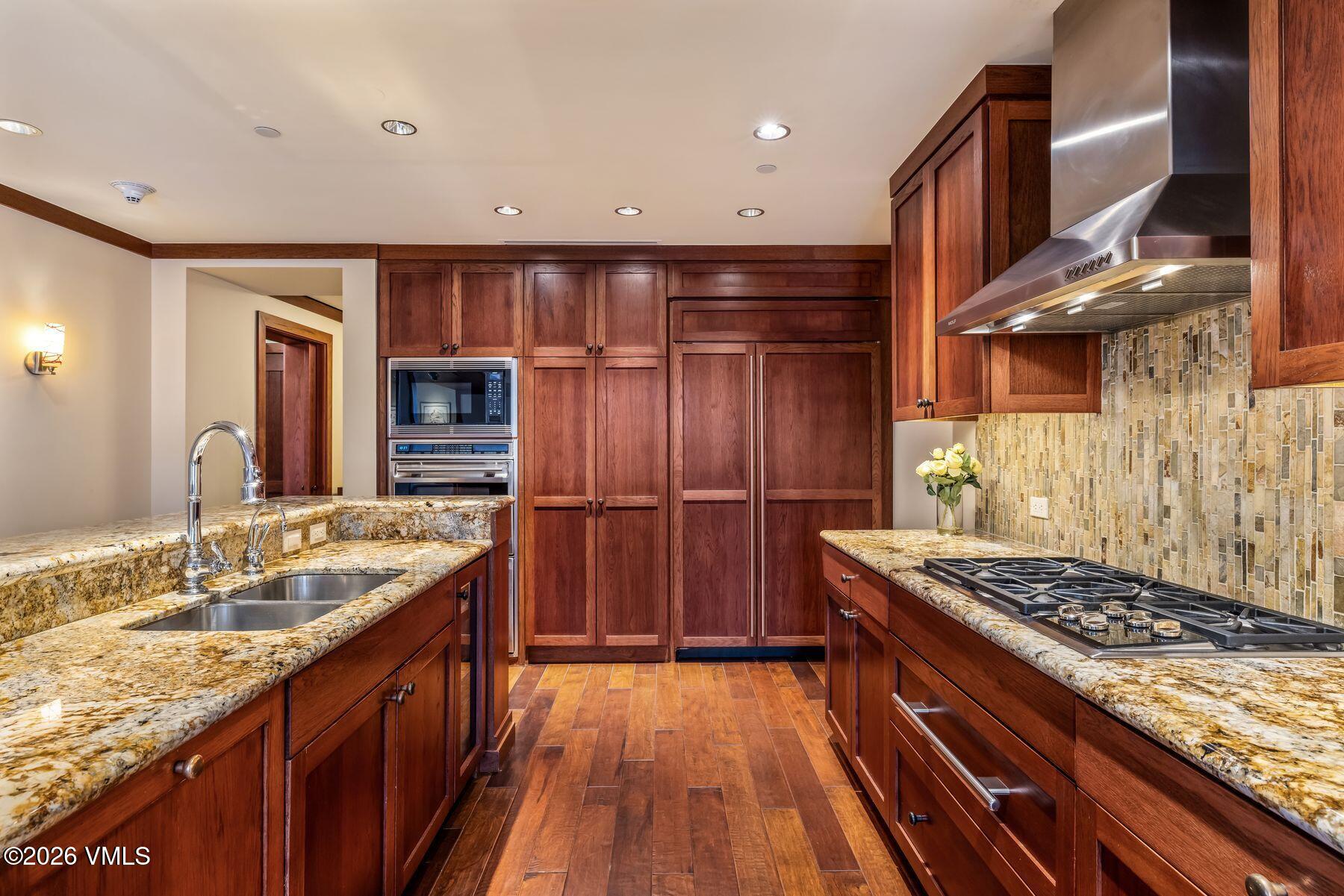 1 Vail Road, Unit 9204 Vail, CO 81657 - Photo 10 of 27 a kitchen with wooden cabinets and a stove top oven