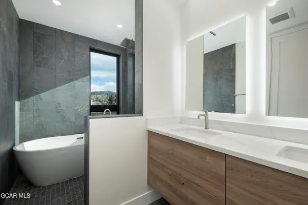 a bathroom with a double vanity sink and mirror