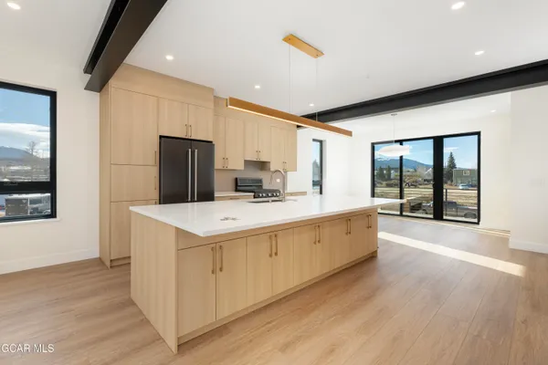 a large white kitchen with a large window