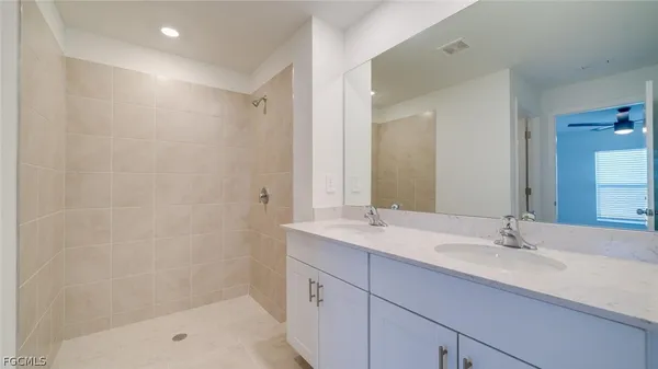 a bathroom with a shower sink vanity and mirror