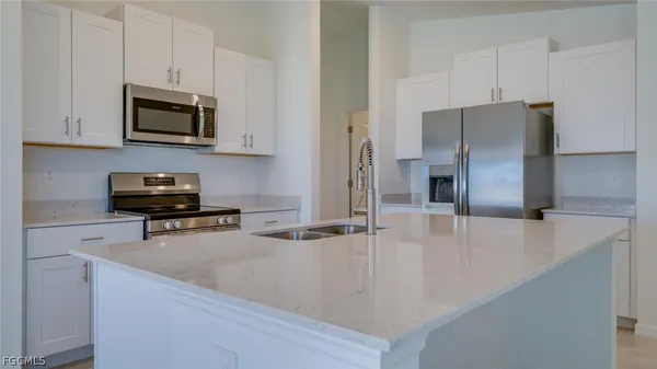 a kitchen with a refrigerator and a stove top oven