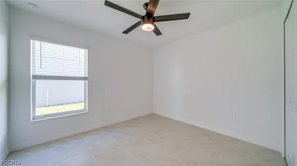 an empty room with a window and a fan