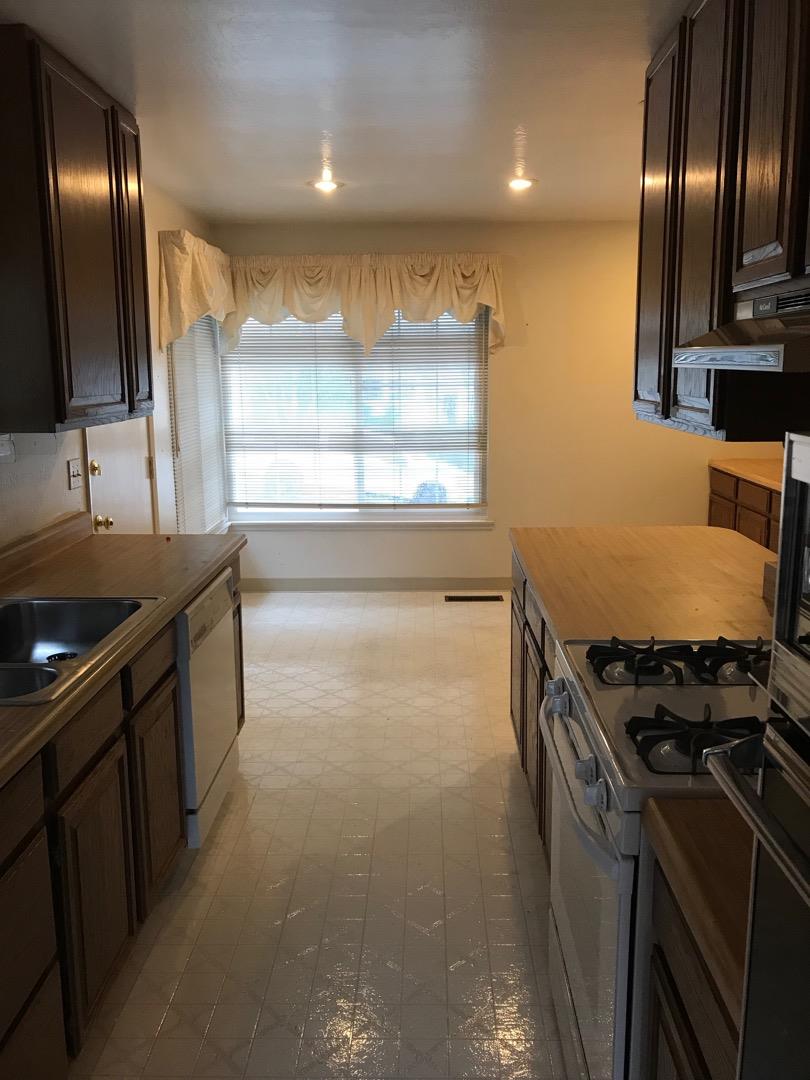 1273 Aspen Drive Pacifica, CA 94044 - Photo 3 of 12 a kitchen with granite countertop stainless steel appliances a sink a stove and a window