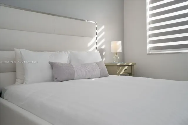 a bedroom with a bed and a large window