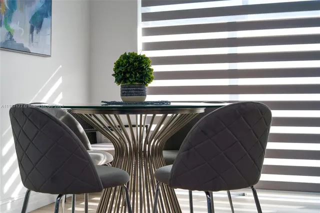 a close view of dining table chairs with a potted plant