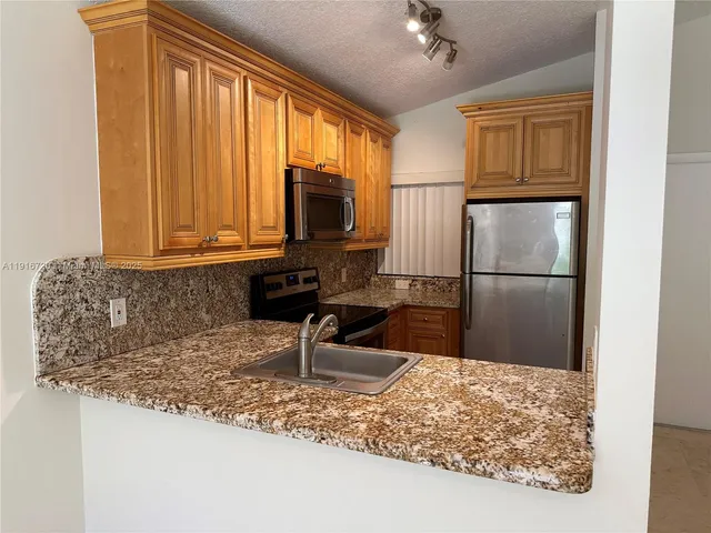 a kitchen with a refrigerator a sink and a window