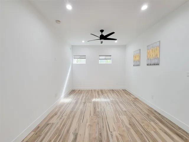 a view of a room with wooden floor and a ceiling fan