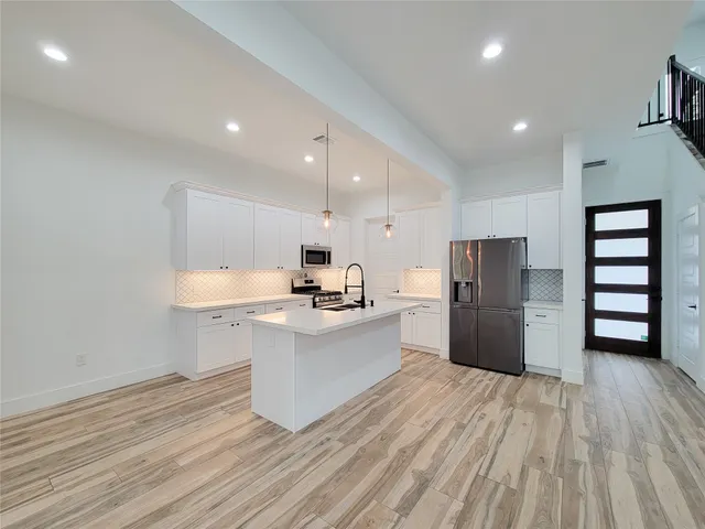a kitchen with a sink a stove and cabinets