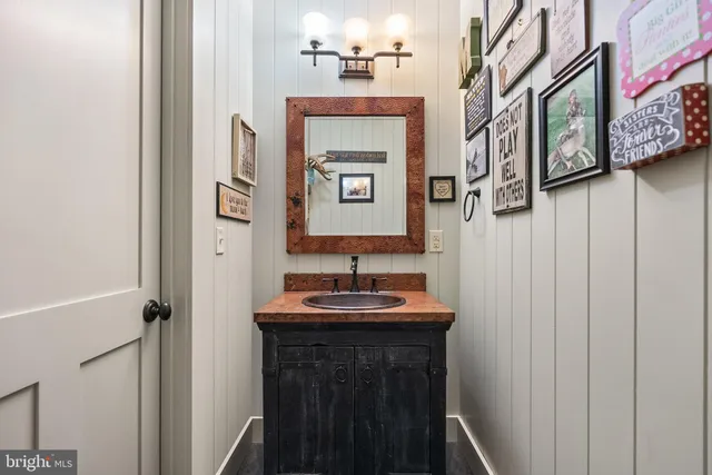 a dining room with wooden floor a chandelier a wooden table and chairs