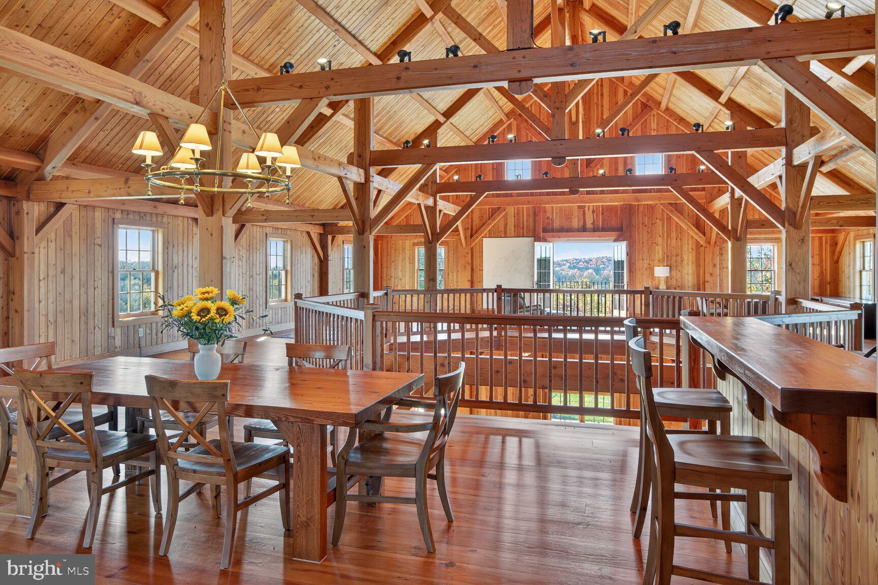 21100 West Offutt Road Poolesville, MD 20837 - Photo 37 of 58 a dining room with wooden floor a chandelier a wooden table and chairs