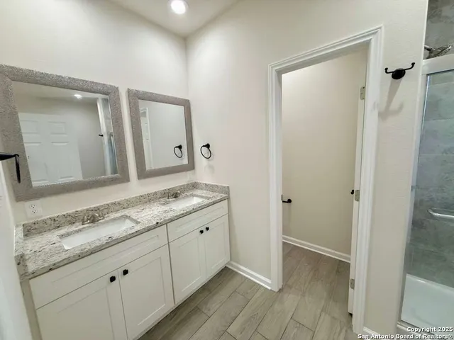 a bathroom with a granite countertop sink and a mirror