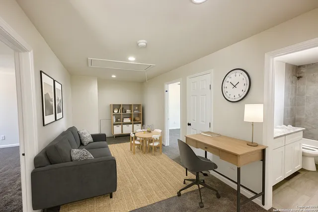 a living room with furniture a clock and a window