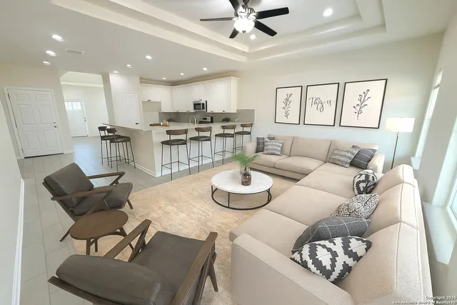a living room with furniture and a view of kitchen
