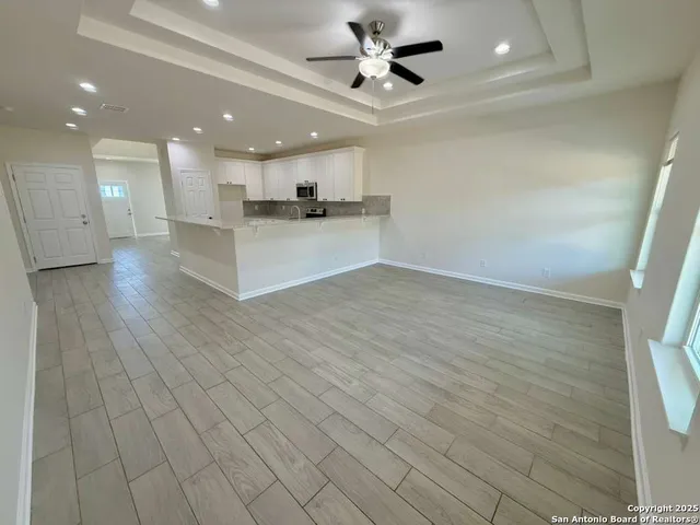 a view of kitchen with kitchen island stainless steel appliances refrigerator stove microwave and cabinets