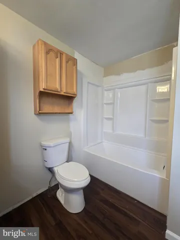 a white toilet sitting next to a bath tub