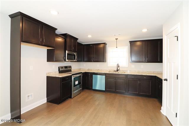 116 Hawks Ridge Byron, GA 31008 - Photo 11 of 34 a large kitchen with stainless steel appliances granite countertop a stove a sink and a microwave