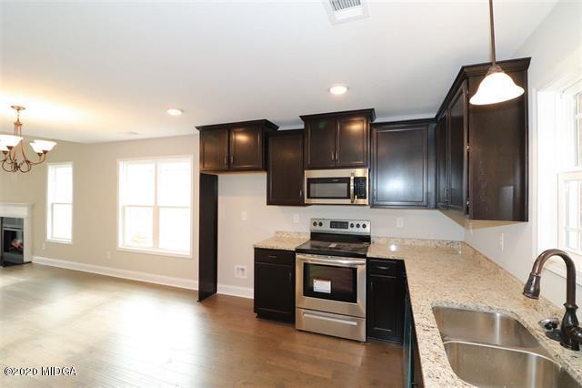 116 Hawks Ridge Byron, GA 31008 - Photo 10 of 34 a kitchen with granite countertop a stove a sink and a refrigerator