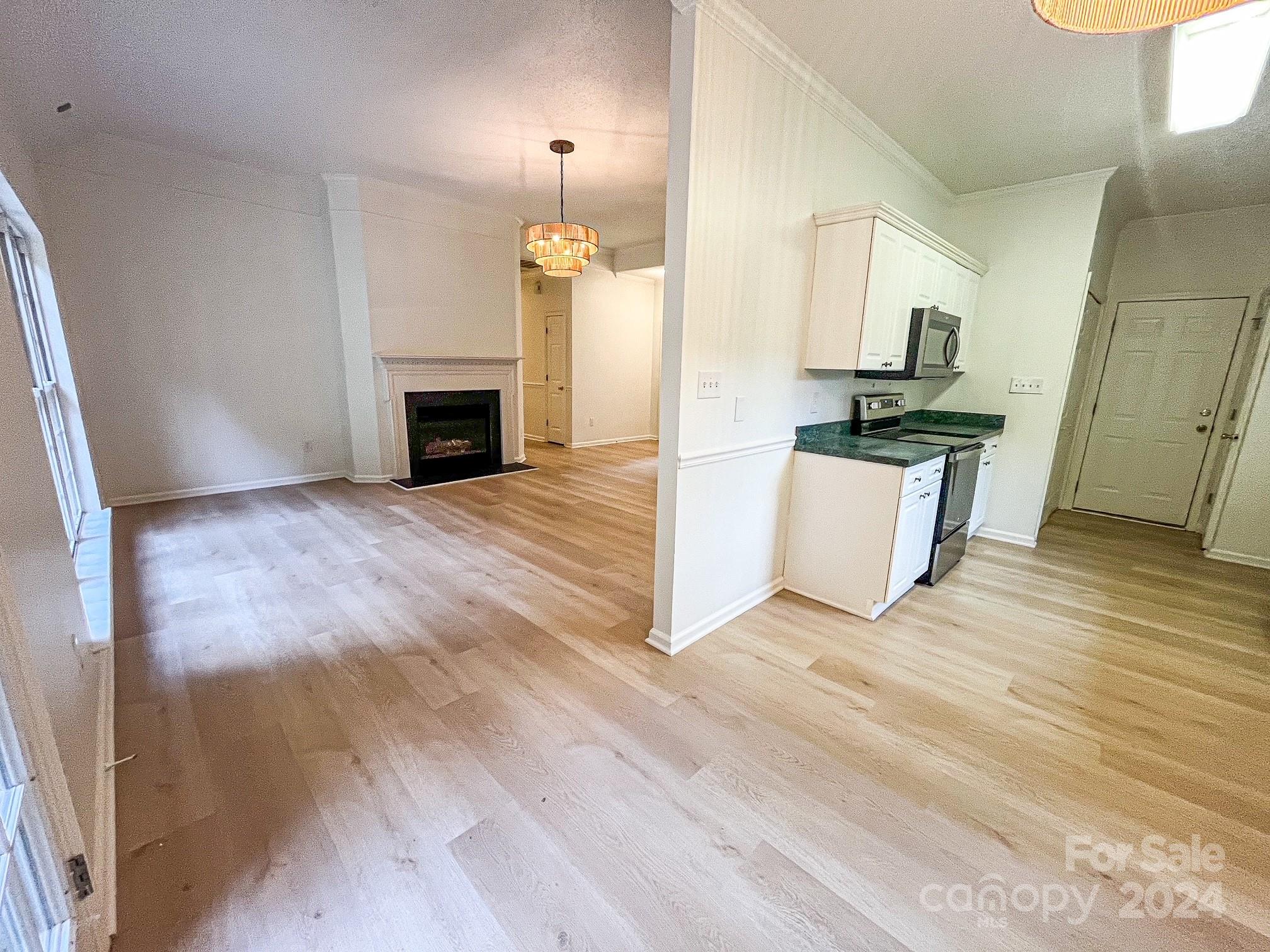 3079 River Ridge Drive Gastonia, NC 28056 - Photo 18 of 24 an empty room with wooden floor fireplace and windows