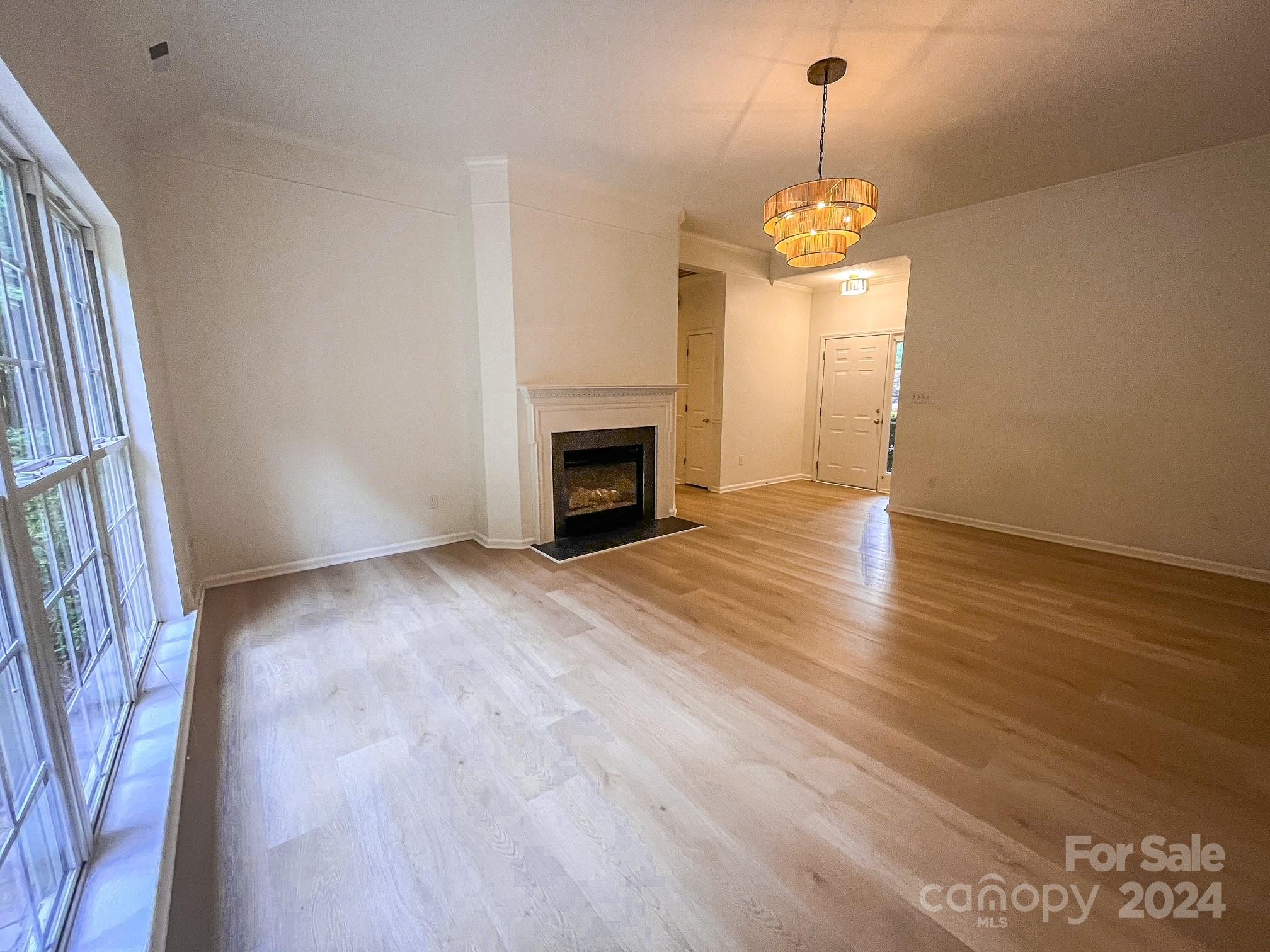 3079 River Ridge Drive Gastonia, NC 28056 - Photo 4 of 24 an empty room with wooden floor fireplace and window