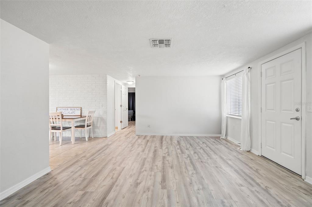3709 Panola Drive New Port Richey, FL 34652 - Photo 17 of 36 a view of a room with wooden floor and a kitchen