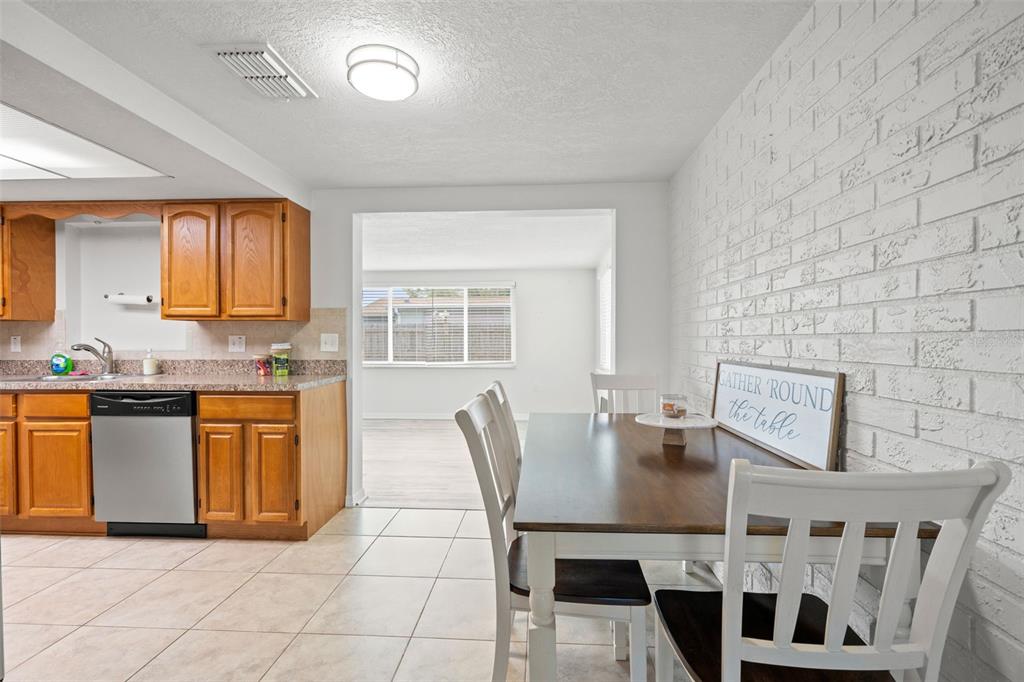 3709 Panola Drive New Port Richey, FL 34652 - Photo 7 of 36 a kitchen with stainless steel appliances granite countertop a stove a sink a microwave and dining table