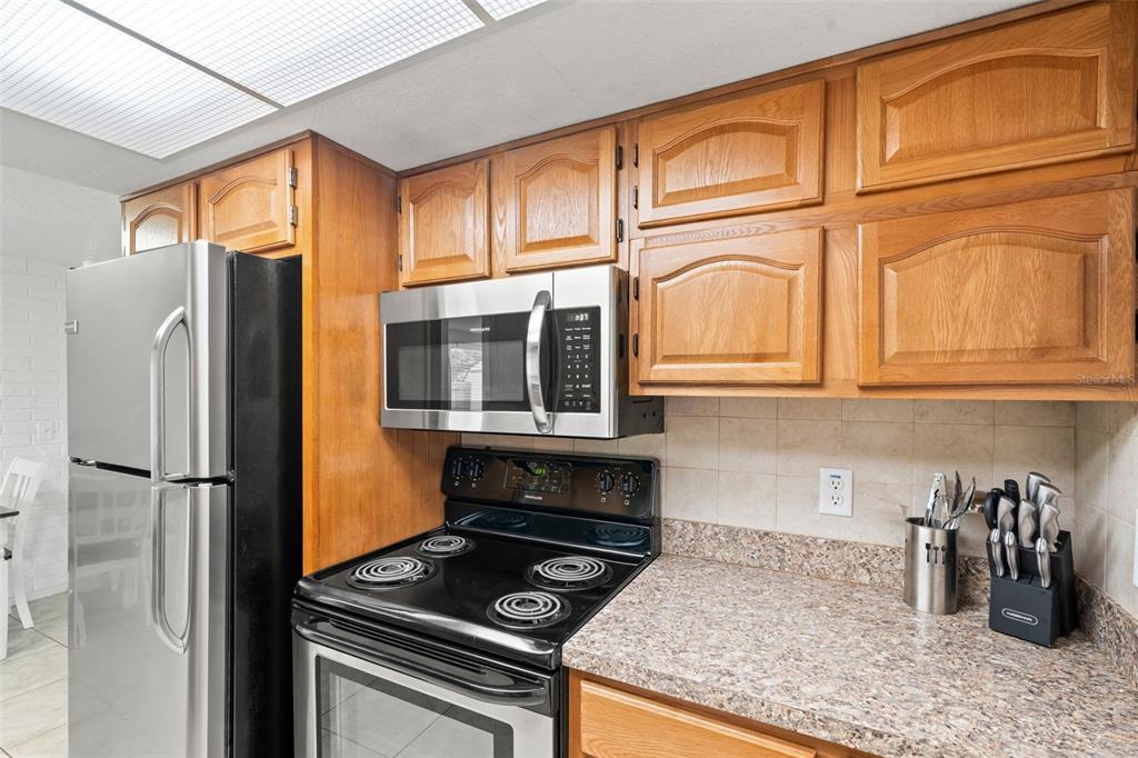 3709 Panola Drive New Port Richey, FL 34652 - Photo 8 of 36 a kitchen with stainless steel appliances granite countertop a refrigerator a stove and a sink with granite countertops