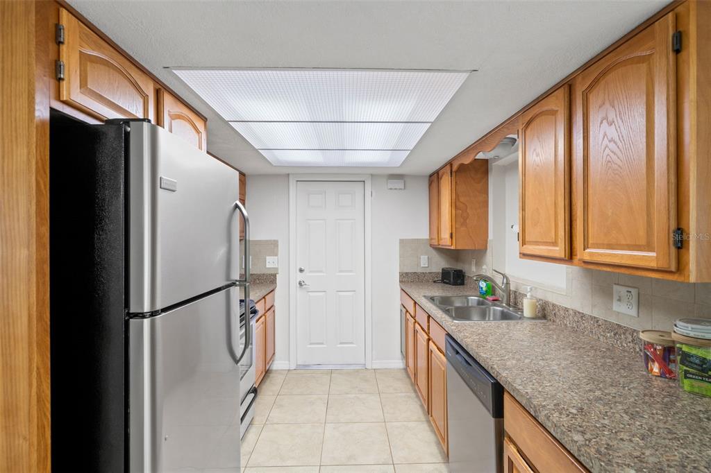 3709 Panola Drive New Port Richey, FL 34652 - Photo 9 of 36 a kitchen with stainless steel appliances granite countertop a refrigerator and a sink