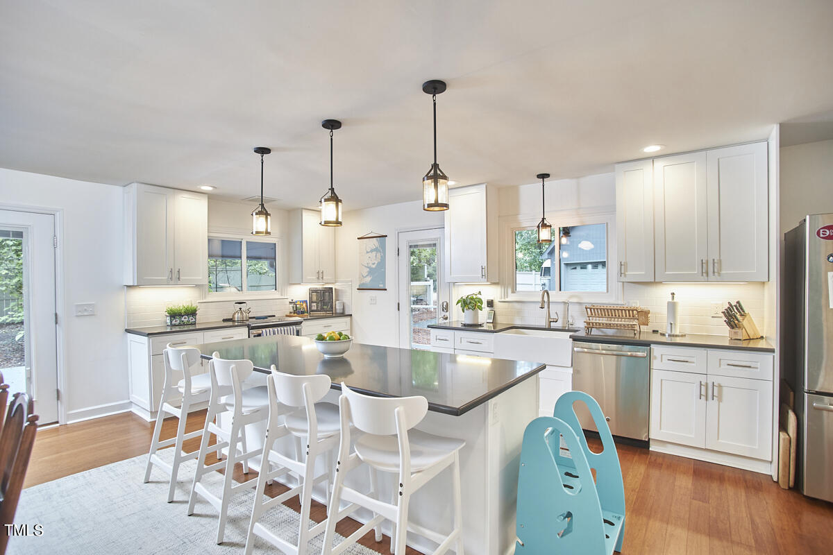 2803 McDowell Road Durham, NC 27705 - Photo 29 of 81 a kitchen with stainless steel appliances kitchen island granite countertop a table chairs and a view of living room