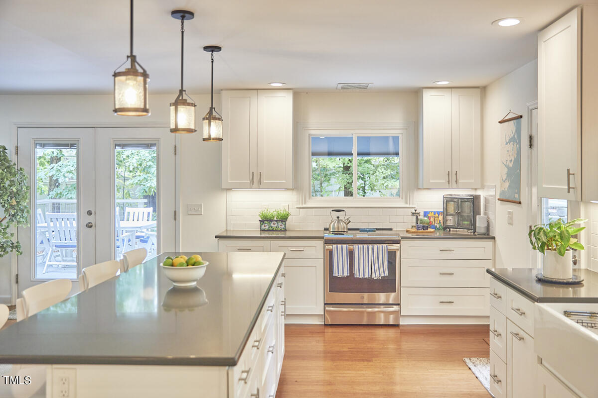2803 McDowell Road Durham, NC 27705 - Photo 37 of 81 a kitchen with stainless steel appliances granite countertop a stove a sink a refrigerator a counter space and living room view