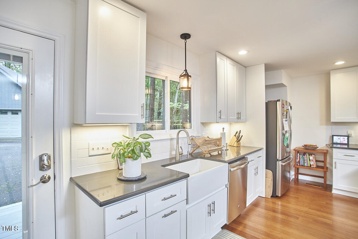 2803 McDowell Road Durham, NC 27705 - Photo 40 of 81 a kitchen with stainless steel appliances granite countertop a sink a stove and a wooden floors