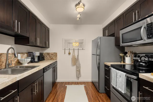 a kitchen with a sink a refrigerator cabinets and a counter top space