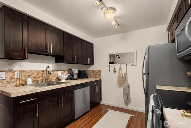 a kitchen with stainless steel appliances a refrigerator sink and cabinets