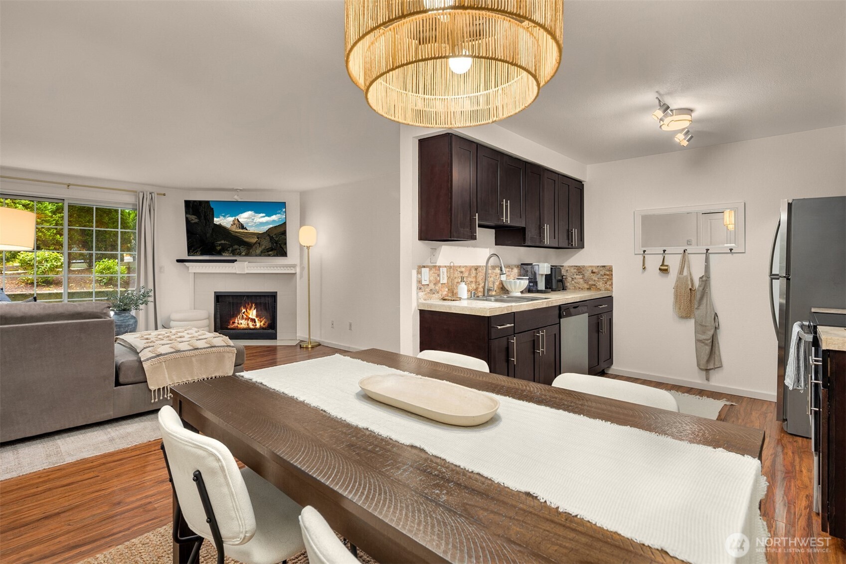 215 9th Street, Unit D102 Kirkland, WA 98033 - Photo 18 of 32 a kitchen with a table chairs refrigerator and a fireplace