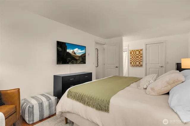 a bedroom with a bed a mirror and a flat screen tv