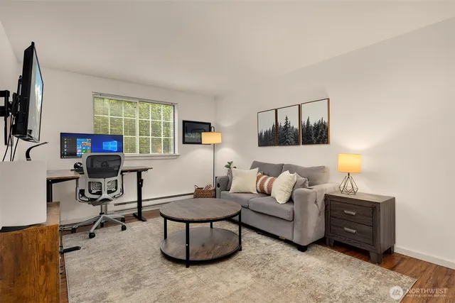 a living room with furniture a window and a flat screen tv