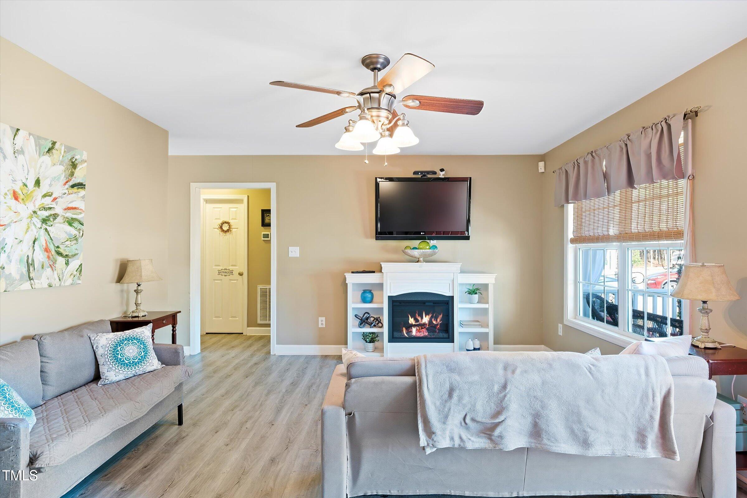 21 Birchwood Circle Coats, NC 27521 - Photo 15 of 36 a living room with furniture a flat screen tv and a fireplace