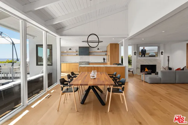 a large kitchen with a large counter top a sink stainless steel appliances and cabinets