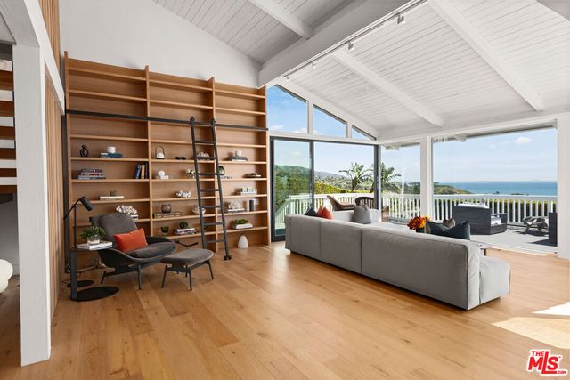 a living room with furniture and a floor to ceiling window