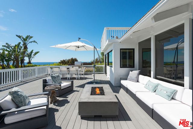 a living room with patio furniture and a potted plant