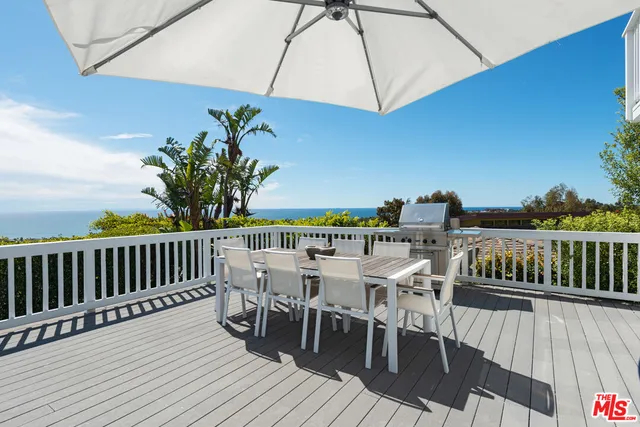 a view of a roof deck with table and chairs