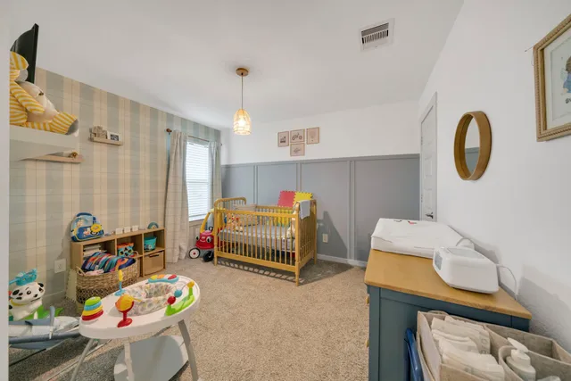 a living room with furniture and a baby crib