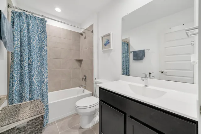 a bathroom with a sink a toilet a mirror and shower