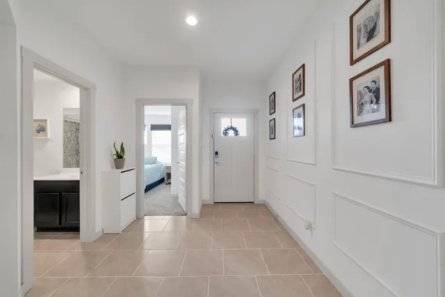 a view of a hallway with wooden floor and a bathroom