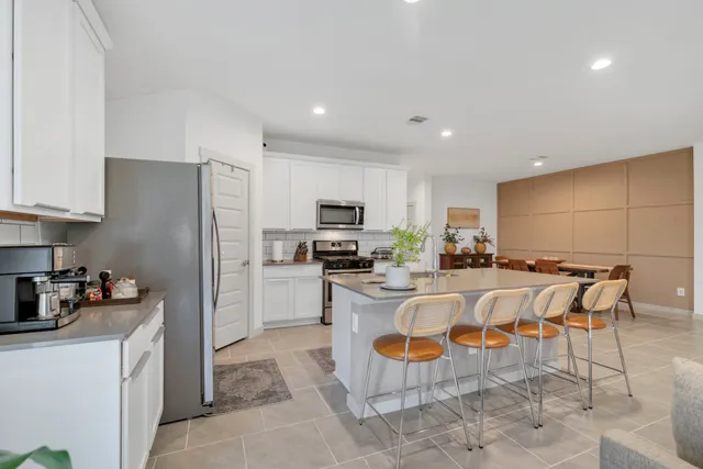 a kitchen with stainless steel appliances granite countertop a refrigerator and a stove top oven