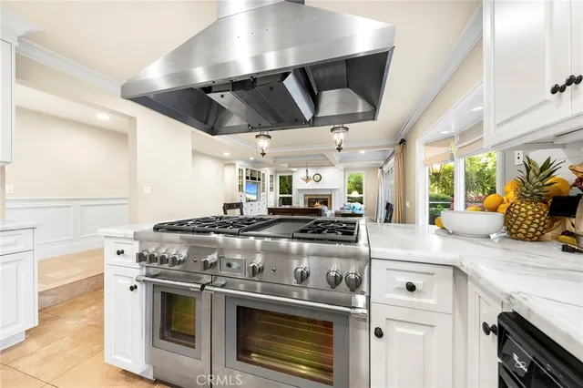 a dining room with wooden floor a chandelier a wooden table and chairs