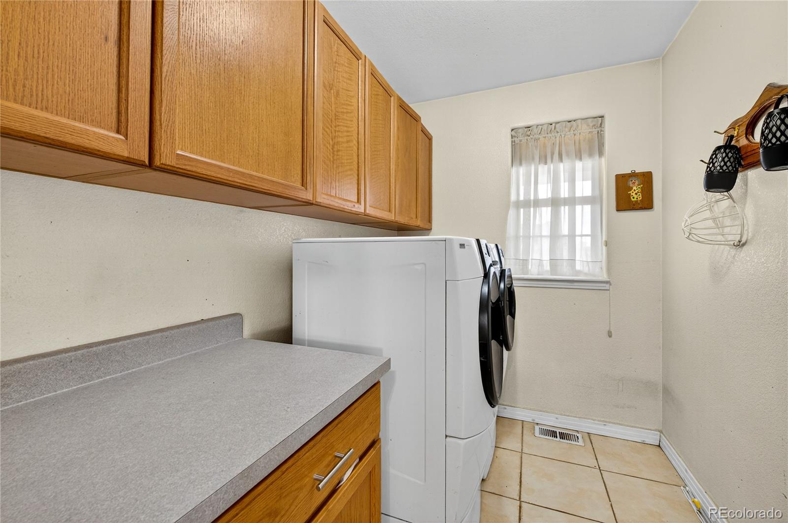 2464 Remington Road Elizabeth, CO 80107 - Photo 15 of 41 a utility room with granite countertop cabinets washer and dryer