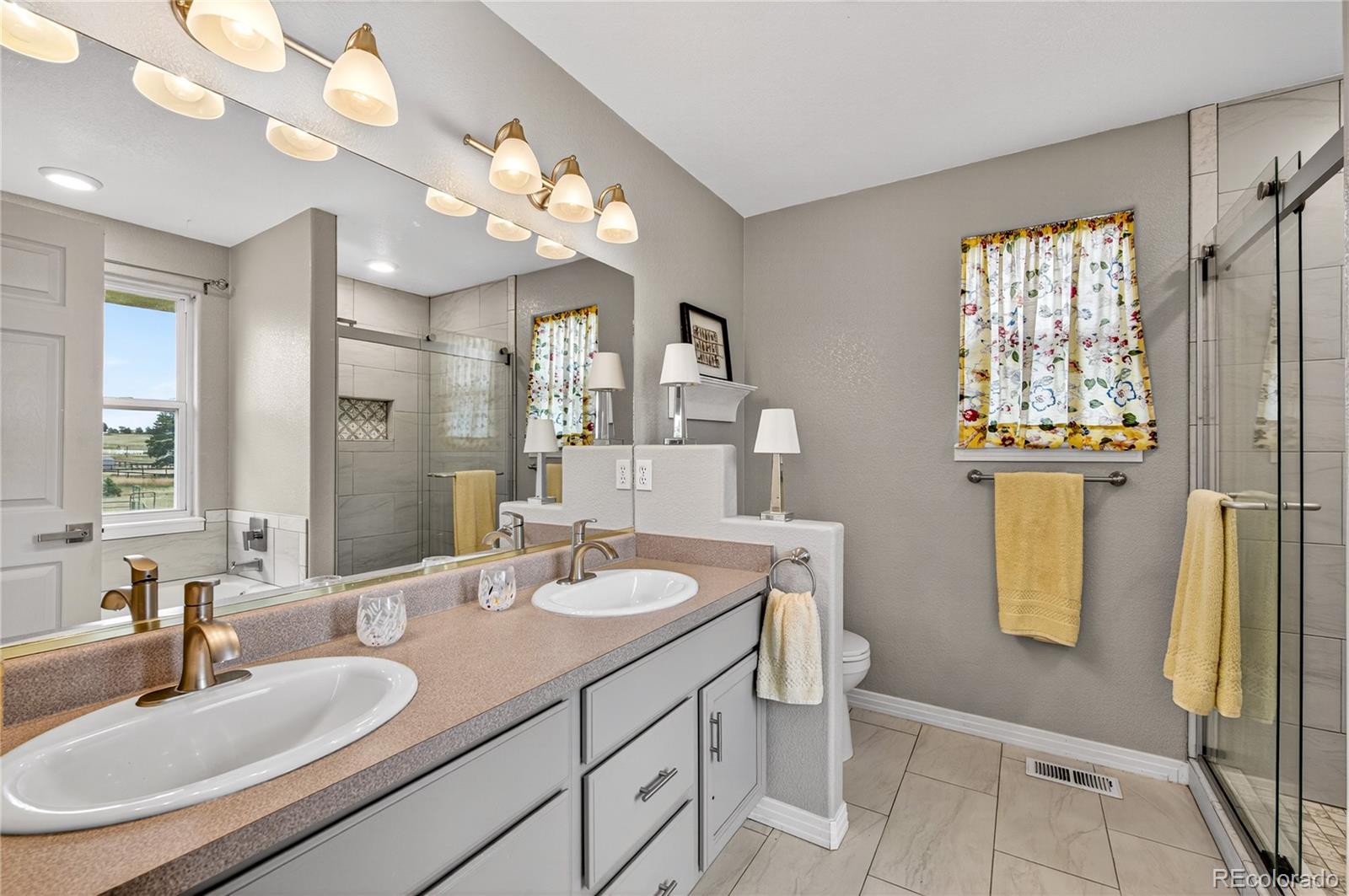 2464 Remington Road Elizabeth, CO 80107 - Photo 19 of 41 a bathroom with a sink a mirror and a shower