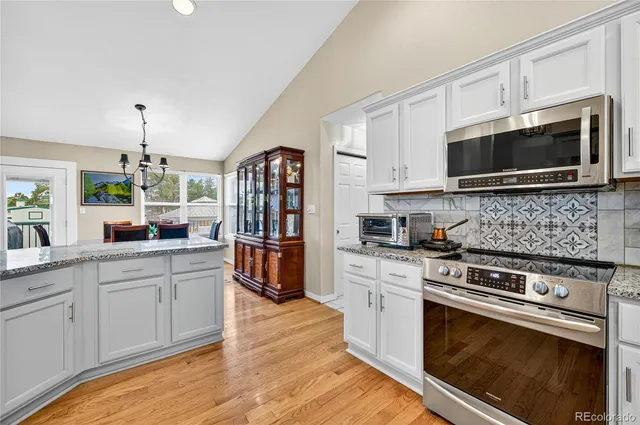 a kitchen with stainless steel appliances white cabinets a stove top oven a sink and dishwasher